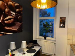eine Küche mit einem Tisch mit zwei Lampen und einem Fenster in der Unterkunft Stadtoase 2 in Wittenberge + 11 Fotos