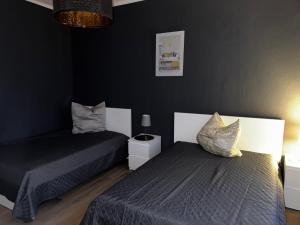 zwei Betten in einem Schlafzimmer mit schwarzen Wänden in der Unterkunft Stadtoase 2 in Wittenberge