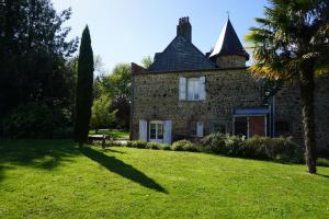an old brick house with a tree in the yard at Le Petit Lustucru in Saint-Martin-des-Champs