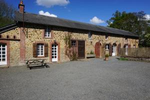 a stone building with a bench in front of it at Le Petit Lustucru in Saint-Martin-des-Champs