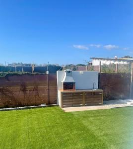 a garden with a grill in the grass at El Palmar Paradise in El Palmar