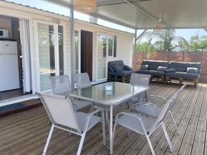 a patio with a table and chairs on a deck at El Palmar Paradise in El Palmar