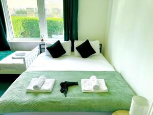 a bedroom with a bed with towels and a window at Chic victorian 1 bed flat - sleeps 4 - free parking - pet friendly in Bradford