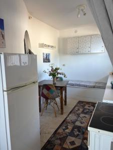 a kitchen with a white refrigerator and a table at Villa Noza Kalamos in Kalamos
