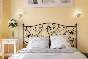 a bedroom with a bed with a black and white headboard at Chambre d'hôtes Les Loges in Luçon