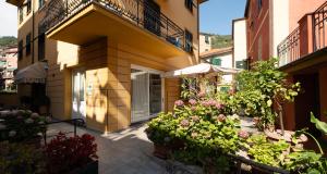 a building with a bunch of flowers and an umbrella at Hotel Margherita in Monterosso al Mare