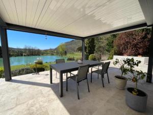 a patio with a table and chairs and a view of a lake at L isaro in Anthé
