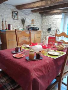 a table with a red table cloth with food on it at L isaro in Anthé