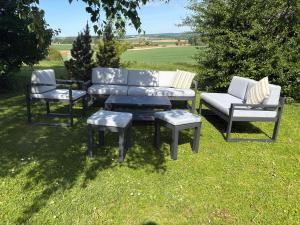 three chairs and a couch and a table in the grass at Villa Leynie in Festalemps +28 photos