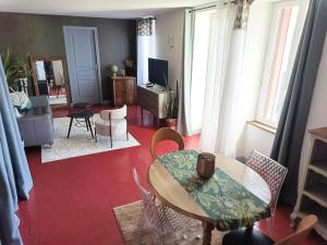 a living room with a table and chairs at Maison les Alouettes in Nevers