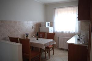 a kitchen with a table and chairs with a white table cloth at Sárga Apartman Ház in Balatonfüred