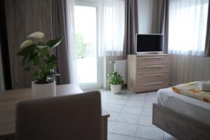 a bedroom with a bed and a tv on a dresser at Sárga Apartman Ház in Balatonfüred