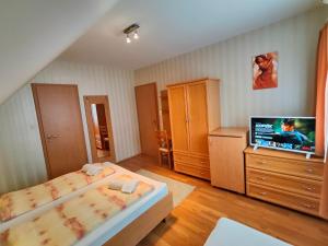 a bedroom with a bed and a flat screen tv at Sárga Apartman Ház in Balatonfüred