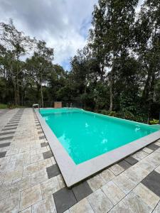 an empty swimming pool in a yard with trees at CoffeeLand in Padinjarathara