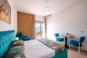 a bedroom with a bed and a table and chairs at Saranda Blueriver apartment in Sarandë