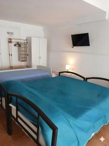 a bedroom with a bed with a blue blanket at Biancolino Apartments in Nardò