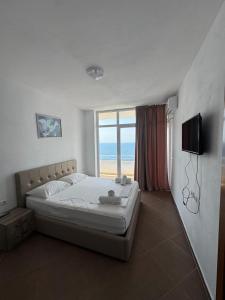 a bedroom with a bed and a view of the ocean at Redi's Seaview Apartments in Sarandë