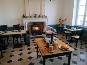 a room with a fireplace and tables and a table with food at La ROCHE D'ANJOU in Saint-Mathurin