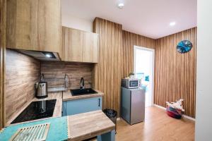 a kitchen with wooden cabinets and a refrigerator at Saranda Blueriver apartment in Sarandë
