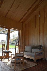a living room with a couch and two chairs at Østhusvik Cabin in Stavanger