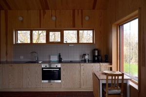 a kitchen with wooden cabinets and a sink and a table at Østhusvik Cabin in Stavanger