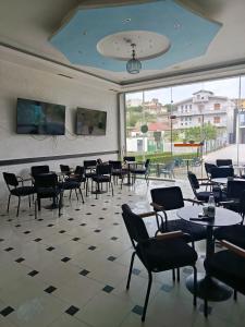 a restaurant with tables and chairs and a large window at Rezidenca Pahumi 2 in Durrës