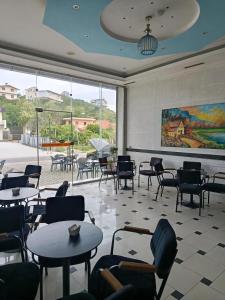 a restaurant with tables and chairs and a painting on the wall at Rezidenca Pahumi 2 in Durrës