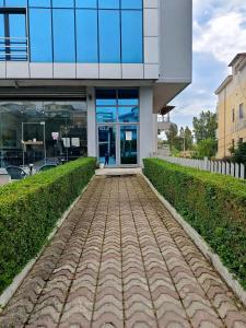 a building with a brick sidewalk in front of it at Rezidenca Pahumi 2 in Durrës