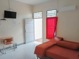 a room with a bed with a red blanket at Verisha Inn Singkawang RedPartner in Singkawang