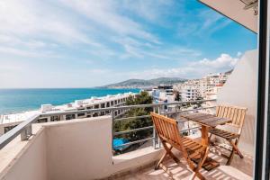 a balcony with a table and chairs and the ocean at Saranda Blueriver apartment in Sarandë