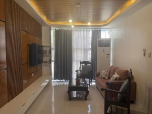a living room with a couch and a tv at Berchby Loft in Digos