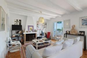 a living room with white furniture and a fireplace at Puigvermell in Pals