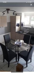 a dining room with a glass table and chairs at Maison à proximité des plages in Bénodet