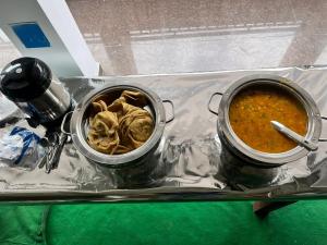 two pots of food sitting on a table at Kedar Mount View in Sonprayag +13 photos