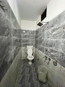a bathroom with a white toilet in a room at Kedar Mount View in Sonprayag