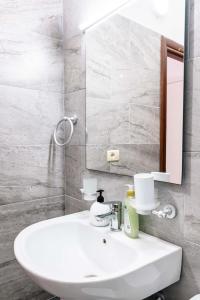 a bathroom with a white sink and a mirror at Saranda Blueriver apartment in Sarandë