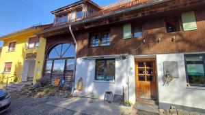 a yellow and white house with a wooden door at Sonnentor in Bad Wurzach