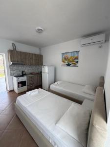 a small room with two beds and a refrigerator at Redi's Seaview Apartments in Sarandë