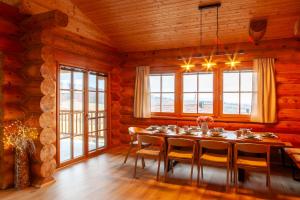 a dining room with a table and chairs and windows at Srub Chodov in Chodov