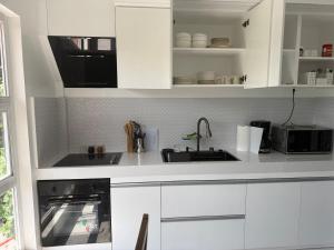a white kitchen with a sink and a microwave at Berchby Loft in Digos +8 photos