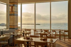 a restaurant with tables and chairs and a view of the ocean at Hotel Riviera Costa del Sol - Adults Recommended in Benalmádena