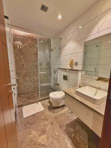 a bathroom with a shower and a toilet and a sink at Sawera Grand Luxury Stay Near Golden Temple in Amritsar +40 photos