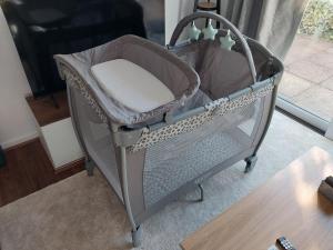 a baby crib sitting in a living room at 2 beds, AC, fully enclosed patio, private parking in Poole