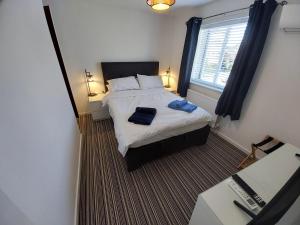 a small bedroom with a bed and a window at 2 beds, AC, fully enclosed patio, private parking in Poole