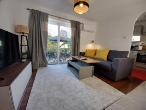 a living room with a couch and a table at 2 beds, AC, fully enclosed patio, private parking in Poole +9 photos