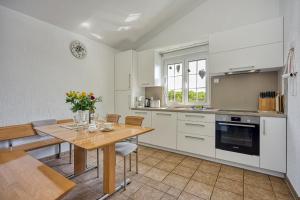 a kitchen with white cabinets and a wooden table at Apartments Covic in Antonci