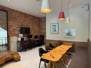 a restaurant with wooden tables and chairs and a brick wall at Ariana Hotel in Daegu