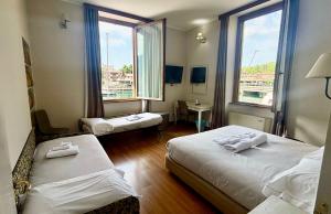 ein Hotelzimmer mit zwei Betten und einem Fenster in der Unterkunft Hotel Sebino in Sarnico