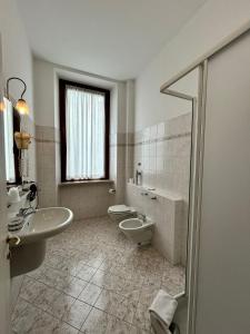 ein Badezimmer mit zwei Waschbecken, Toilette und Dusche in der Unterkunft Hotel Sebino in Sarnico + 26 Fotos