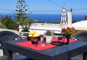 a black table with a basket of fruit and glasses at Despina in Kritinía